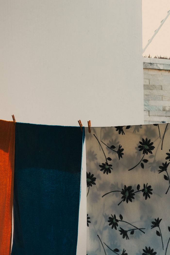why-choose-us Vibrant towels and fabric with floral pattern drying in the sun outdoors.